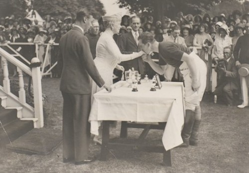 Lord Louis Mountbatten kissing Queen Mary's hand at the prize-giving ceremony after the Duke of York's Cup polo match, Ranelagh, 1 July 1931 [MB2/L4/211