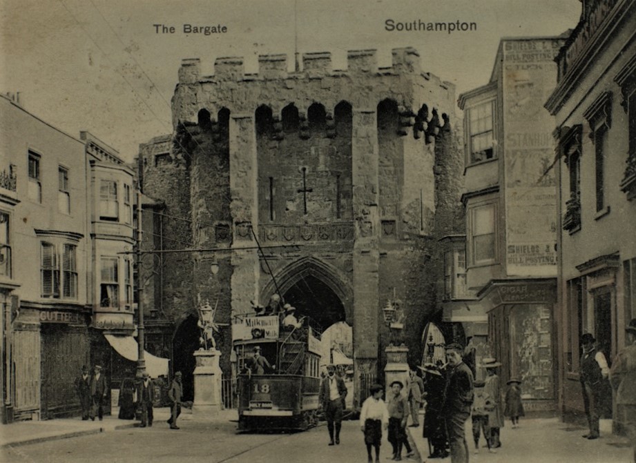 black and white postcard of a tram going through the Bargate